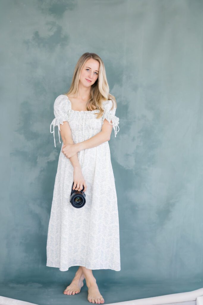 Edina Newborn Photographer Morgan Walworth holds her camera.