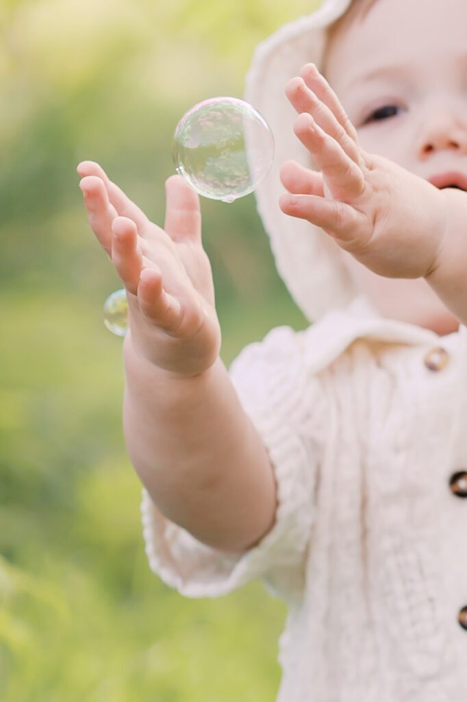 a baby pops a bubble during Family Photos in Lakeville, MN.