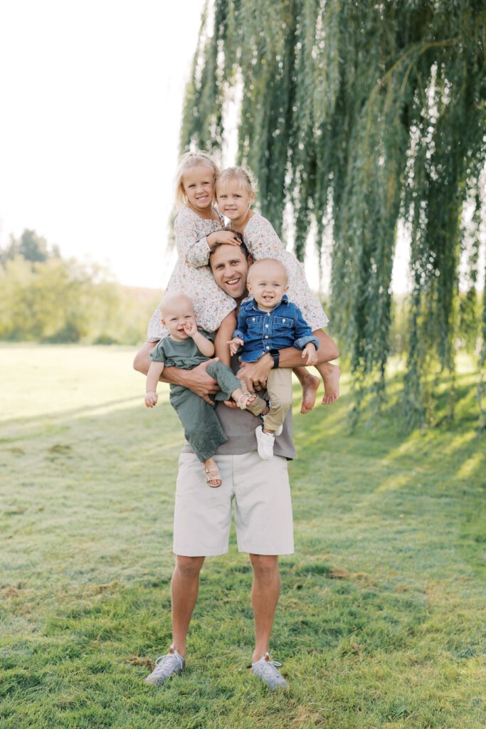 Lakeville Family Photographer, Morgan Walworth photographed a father holding his 4 children.