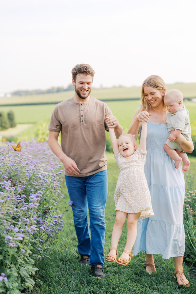 a family plays in a field of flowers during their Family Photos in Lakeville, MN.