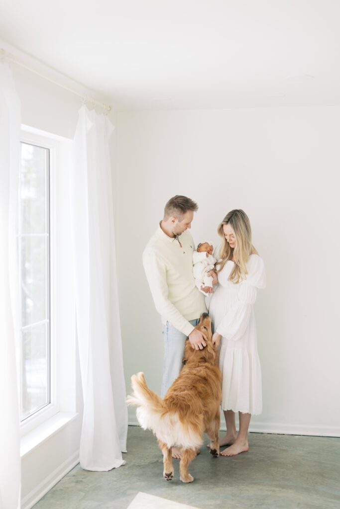 a family embraces their baby and dog during their Edina Newborn Photography session with Morgan Walworth Photography.