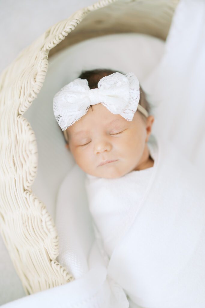 a baby girl sleeps in a bassinet with Edina Newborn Photographer, Morgan Walworth Photography.