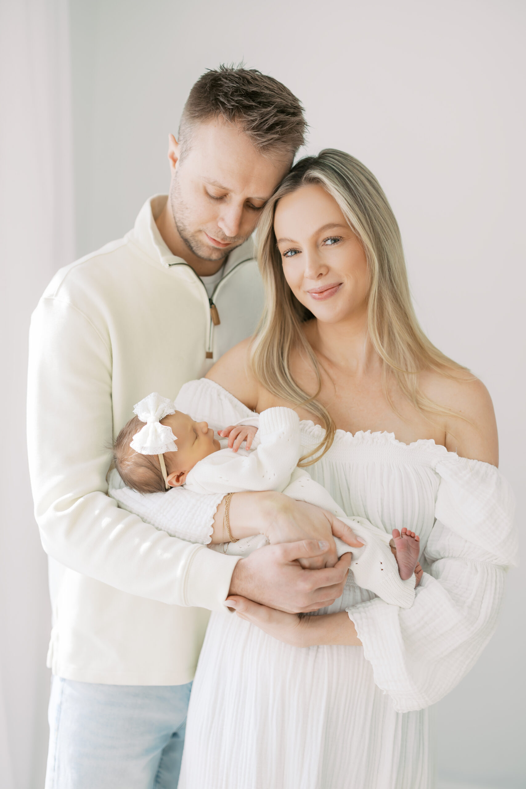 A family holds their newborn baby during their Newborn Photos in Edina, MN with Morgan Walworth Photography