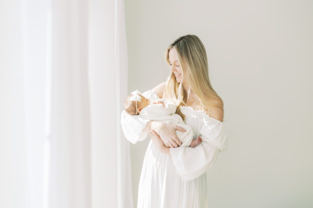 a mother holds her new baby at their Edina Newborn Photos.