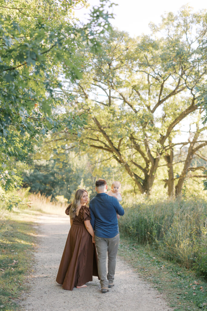a family walks underneath a beautiful tree during family photos in Lakeville.