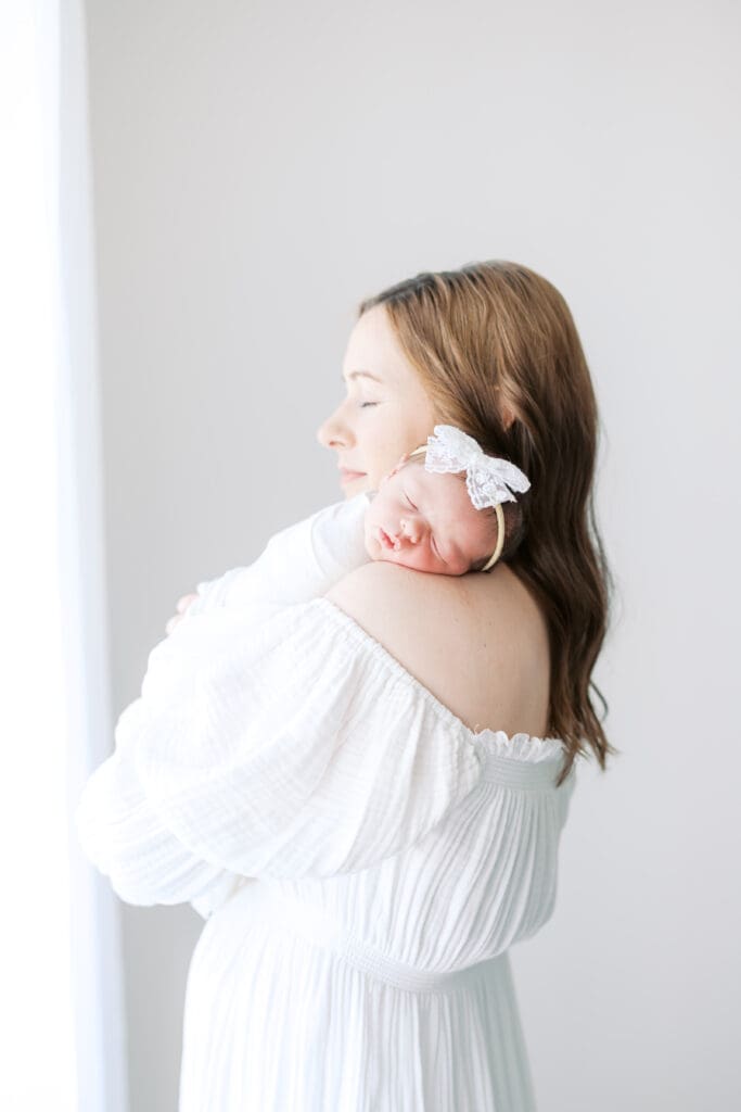 a mother holds her baby during Minneapolis Newborn Photos.