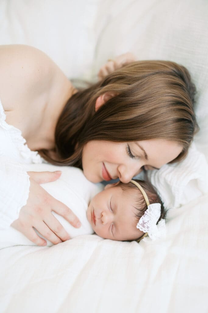a mother snuggles her newborn baby girl during newborn photos in Minneapolis.