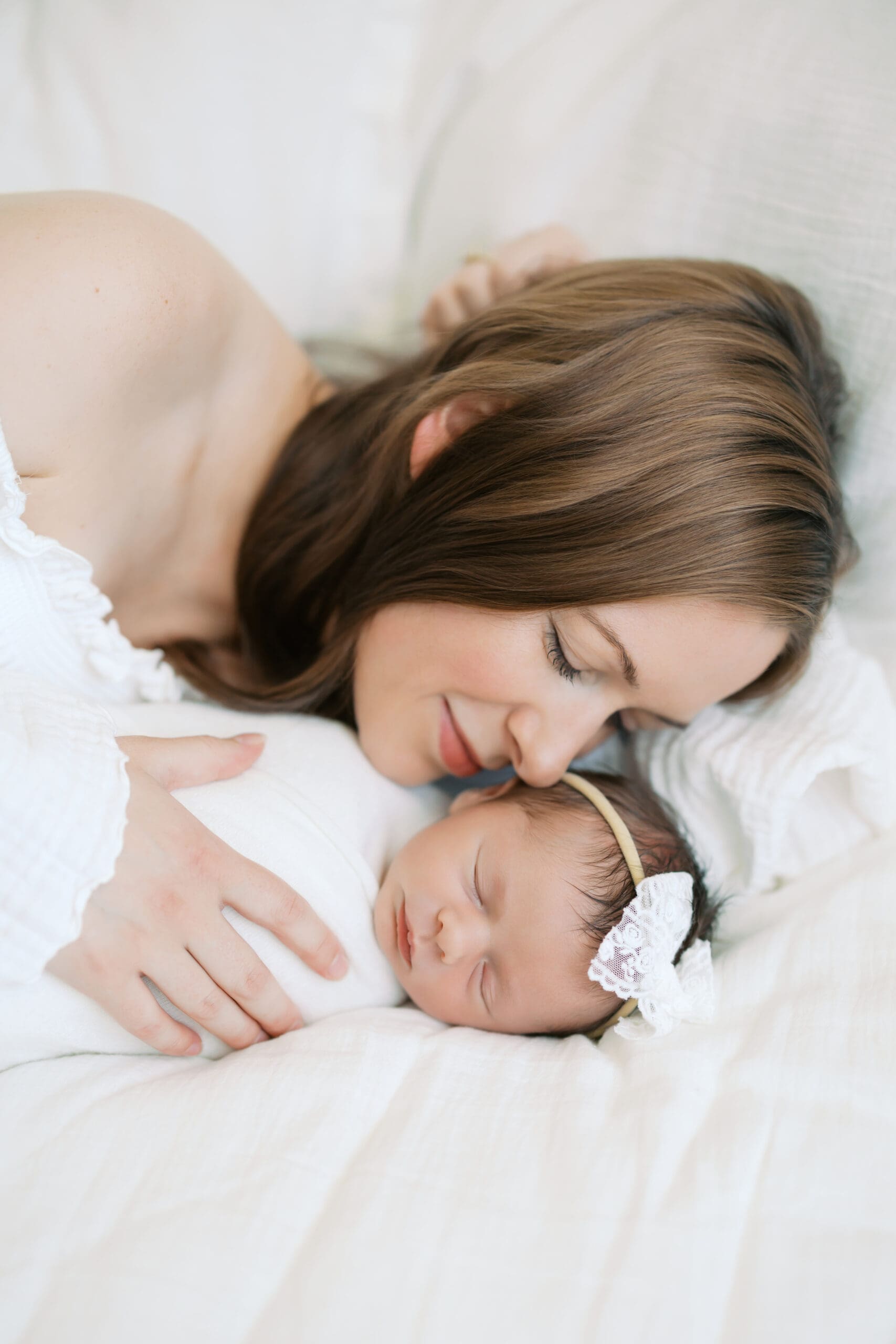a mother snuggles her newborn baby girl during Minneapolis Newborn Photos.