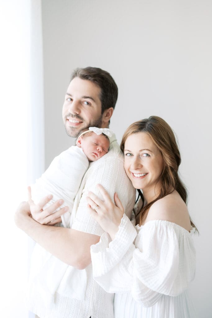a mom and dad hold their new baby during Minneapolis Newborn Photos.